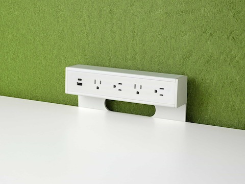 USB-A port, USB-C port, and four A/C power outlets on an attached table power source on green fabric background.