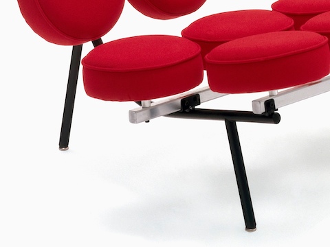 Close view of a red upholstered Nelson Marshmallow Sofa, showing how the round cushions attach to the frame.