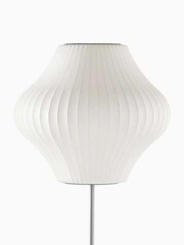 Una lámpara de pie blanca. Seleccione para ir a la página del producto Nelson Pear Lotus Floor Lamp.