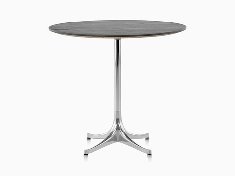 A round Nelson Pedestal Table with a black top and polished aluminum base. 