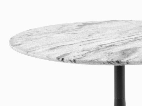 Close view of the white marble top on a round Nelson Pedestal outdoor table. 
