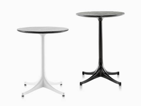 Two round Nelson Pedestal outdoor side tables with black stone tops, one with a white base and one with a black base.