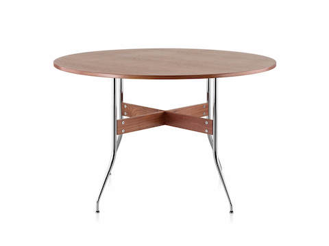 A round Nelson Swag Leg Table in a medium wood finish, showing X-shaped walnut stretchers between tubular steel legs.