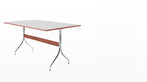 A rectangular Nelson Swag Leg Table with a white top, showing a single walnut stretcher between tubular steel legs.