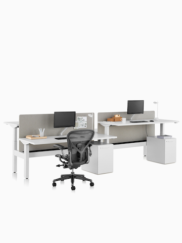 Sistema de escritorios elevados Nevi Link con una silla para oficinas Aeron en negro, pantallas de privacidad, monitores y superficies de trabajo rectangulares. Seleccione para dirigirse a la página del producto Nevi Link.