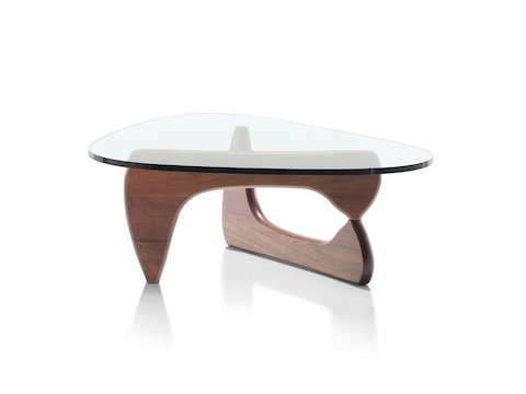 A Noguchi occasional table with a freeform glass top and curved wood base in a medium finish. 