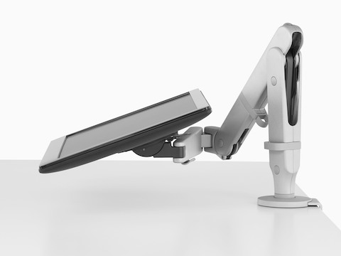 Profile view of an adjustable Ollin Monitor Arm supporting a monitor at an extremely low angle.