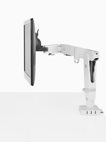 Profile view of a monitor supported by an Ollin Monitor Arm that's connected to a Flo Power Hub with three USB ports.