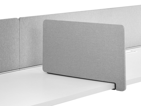 A gray fabric rectangular Personal Side Screen attached to a Layout Studio bench with a gray, flat-edge fabric, center privacy screen.