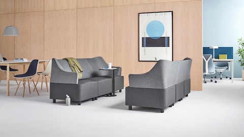 Plex modular elements form two gray sofas facing each other in an informal collaboration setting.