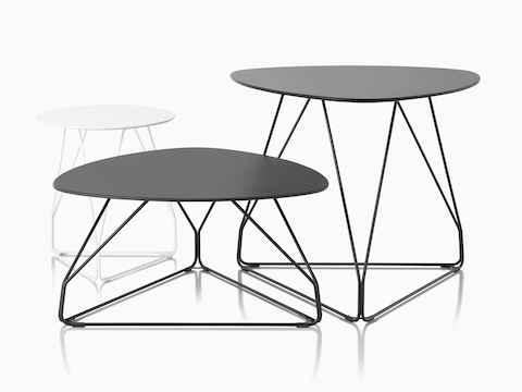 Three Polygon Wire occasional tables. One is white with a round top and the other two are black with rounded triangular tops.