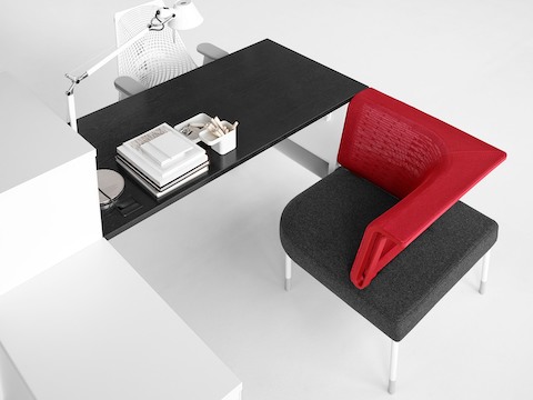 Overhead view of a Public Office Landscape workstation composed of a black surface, white storage, and red social chair.