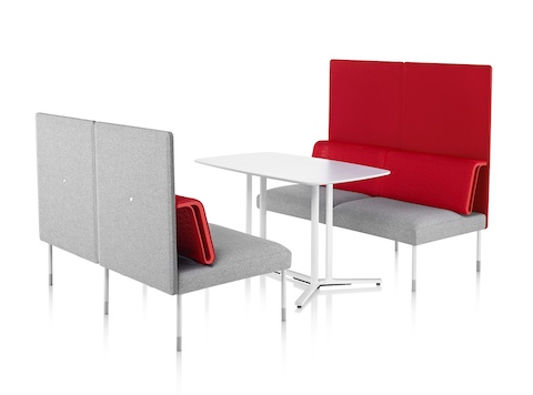 A pair of two-person Public Office Landscape seats in red and grey face each other with a rectangular table between.