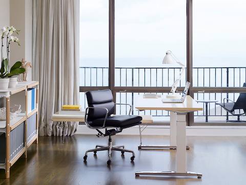 An office with a Renew Sit-to-Stand Table, an Eames Soft Pad Management Chair, a Nelson Platform Bench, and a Magis Steelwood Shelf.