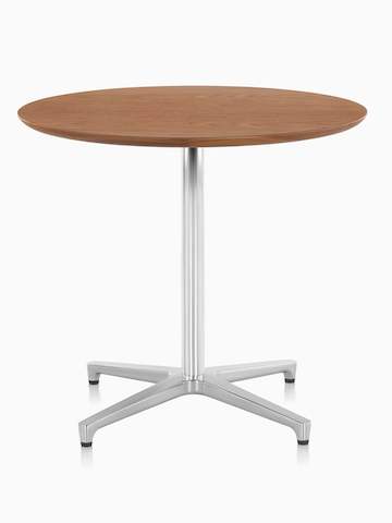 A round Saiba Table with a medium wood finish. Select to go to the Saiba Tables product page.