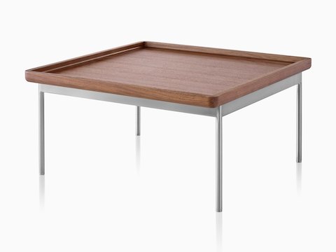 An angled view of a rectangular Tuxedo Table with a medium woodgrain finish and silver metal base.