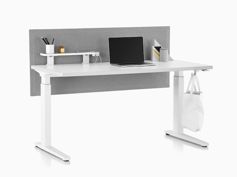 Una mesa rectangular de pie a lado equipada con herramientas de trabajo Ubi, que incluye un estante adjunto, un módulo de alimentación USB y un gancho para la bolsa.