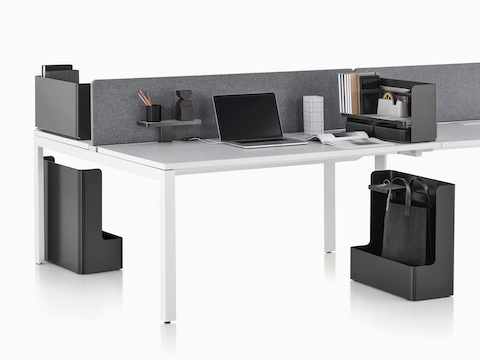 A work surface equipped with Ubi Work Tools, including an attached shelf, desktop organizer, and mobile bag catch.