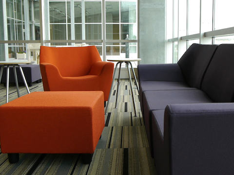 A lounge area setup with navy blue and burnt orange Swoop seating. 