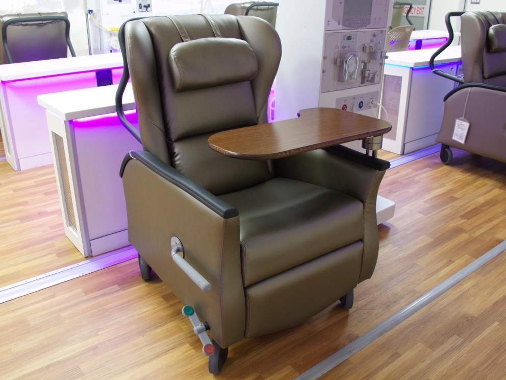 A brown Nemschoff Serenity Chair sits inside of a mobile dialysis unit. 