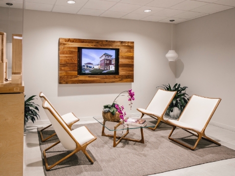 An inviting office lobby features Geiger Scissor chairs and a glass coffee table. 