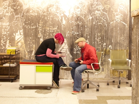Two people converse while sitting on a Meridian cabinet and Setu chair. 