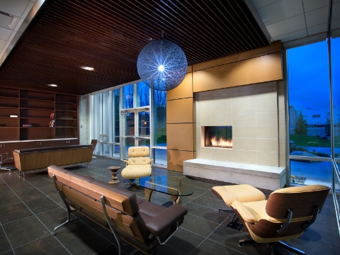 Benches and reclined seating occupy a lounge area centered around a fireplace.