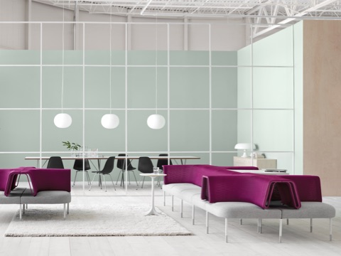 Gray and magenta Public Office Landscape seating adjacent to a glass-walled meeting room containing Eames Molded Plastic Chairs. 