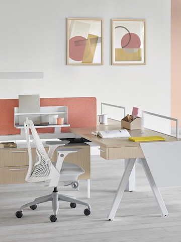 A Canvas Vista desk with a white base and ash surface with a pink tackable screen and a Sayl office chair with a white back and gray base.