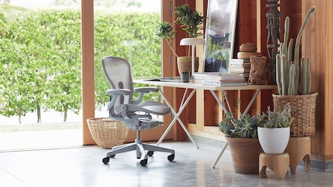 A home office with an Aeron Chair and Nelson X-Leg Table. Select to see office chairs available from the Herman Miller Store.