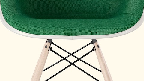 Close view of an Eames chair with green upholstery. Select to read an essay about Charles and Ray Eames and quality.