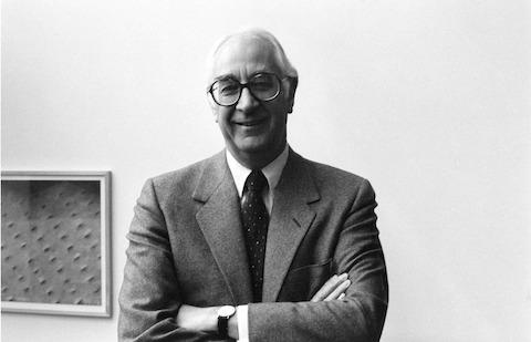A black-and-white image of former Herman Miller CEO Max De Pree with arms crossed.