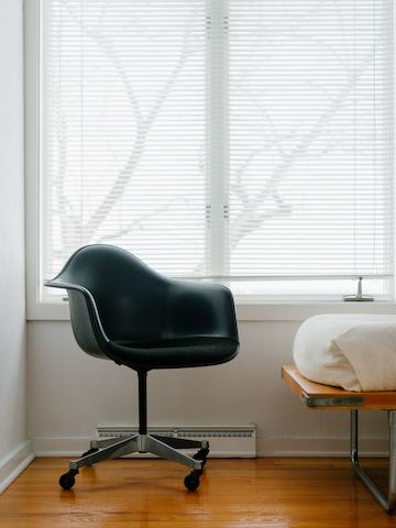 Eames arm chair with naugahyde and hopsack upholstery.