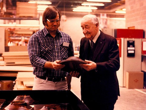 A color photo of Herman Miller founder D.J. De Pree interacting with a factory worker on the plant floor.