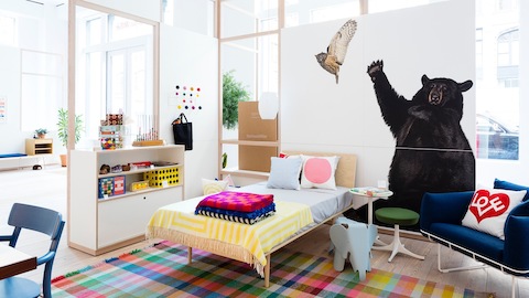 La habitación de un niño con un sofá Wireframe azul. Seleccione para encontrar enlaces a los distribuidores autorizados de Herman Miller.