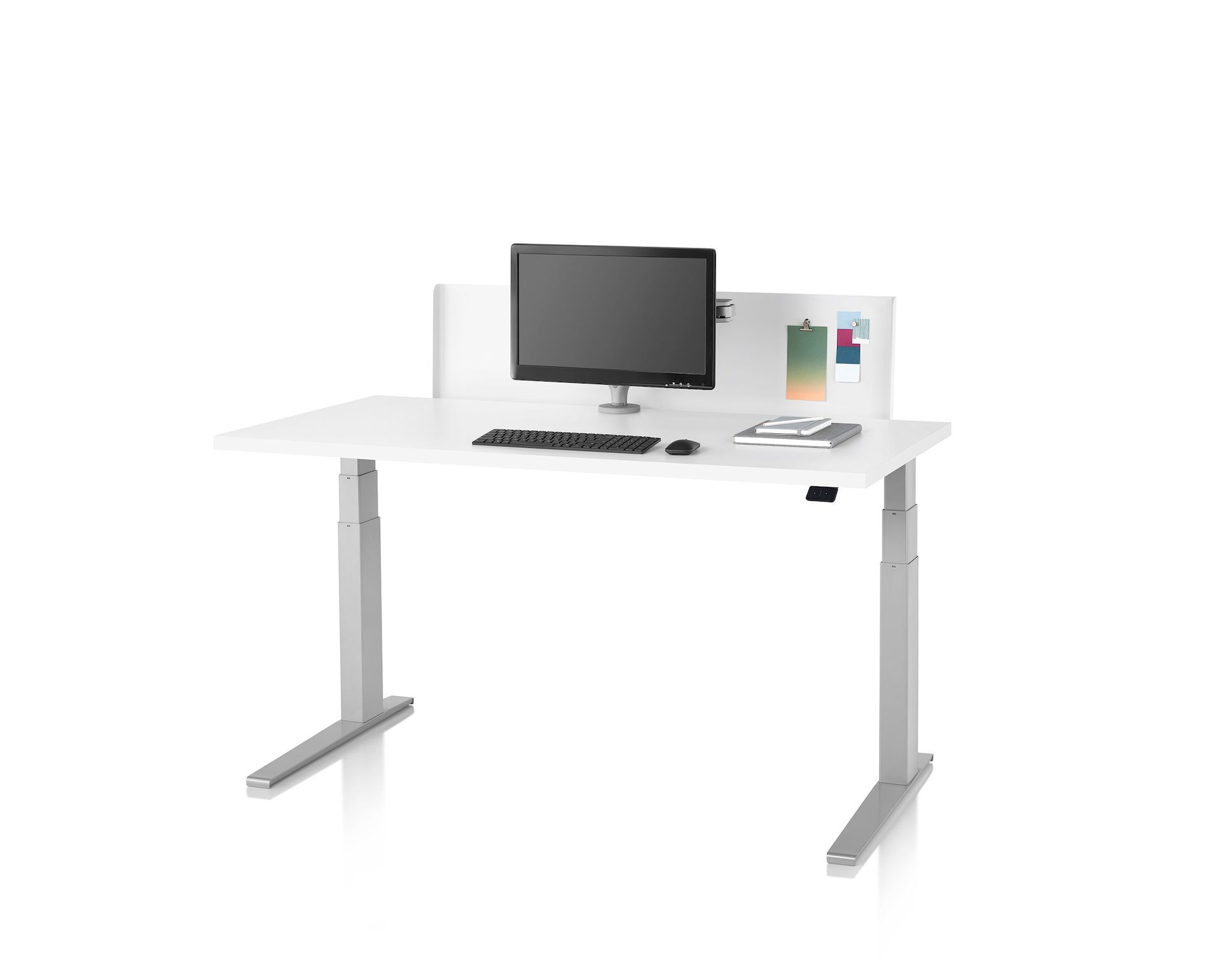A thin white metal privacy screen installed on a Motia Sit-to-Stand Table that has a white top and silver legs.
