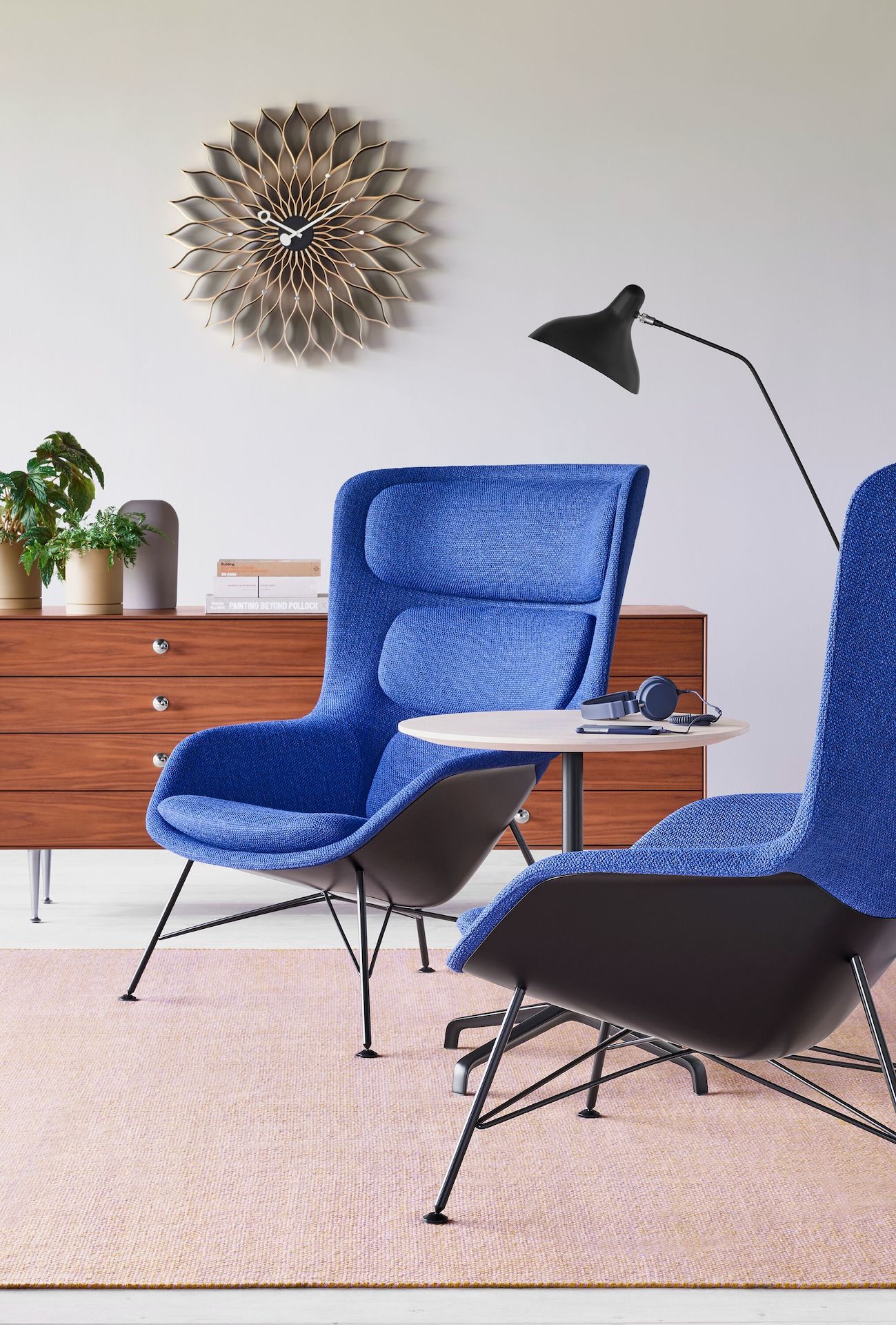 Two blue Striad Lounge Chairs aside a small Striad Table with a white ash top.