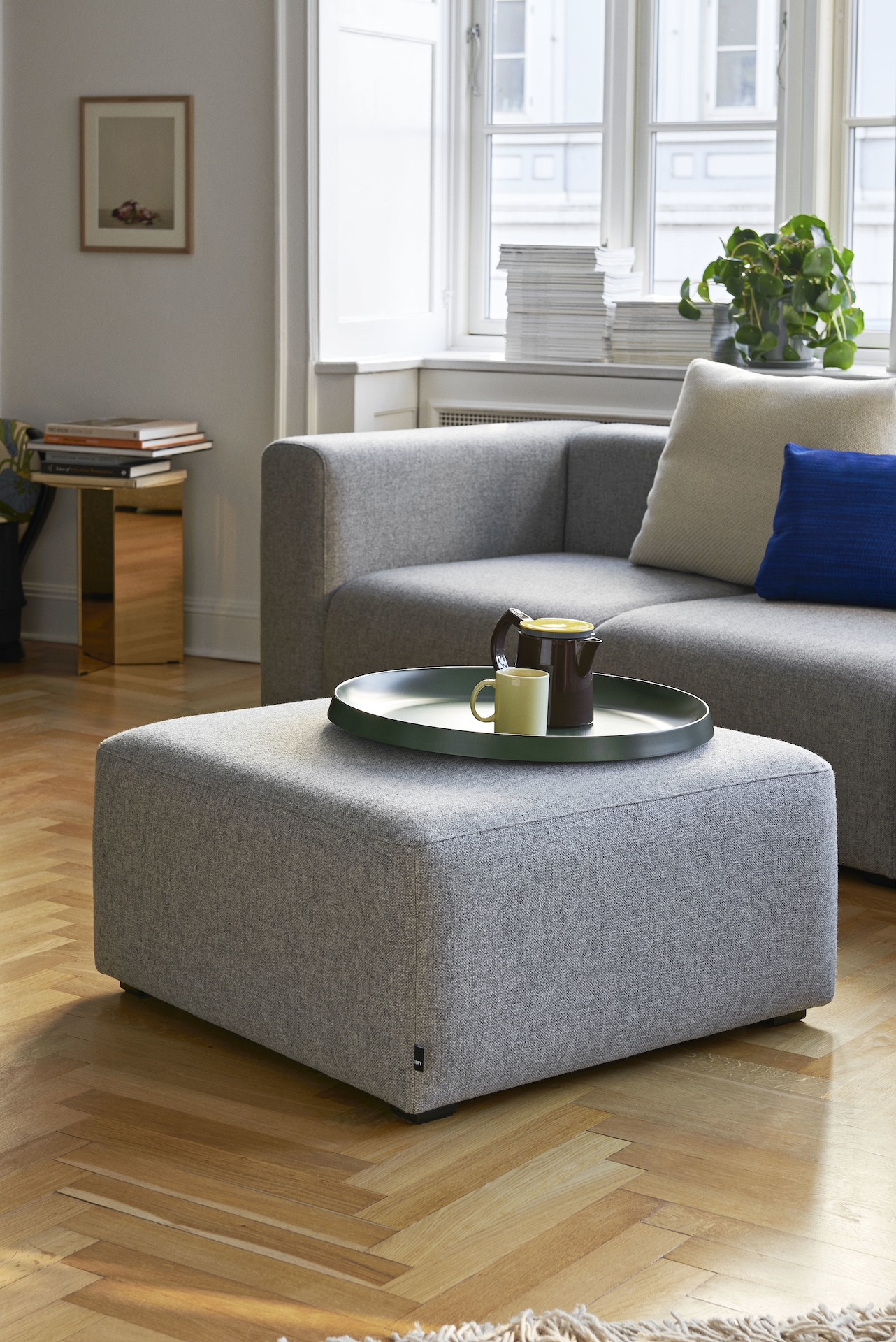 Grey Mags Ottoman, viewed at an angle in front of a grey Mags Sectional Sofa.