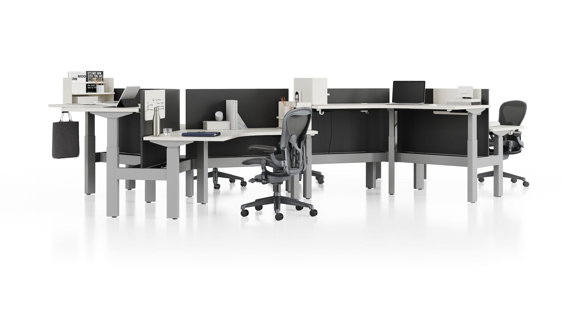 Standing desk system, Nevi Link, with 120-degree work surfaces, privacy screens, and Aeron Chairs.  Two of six desks are raised to standing height.