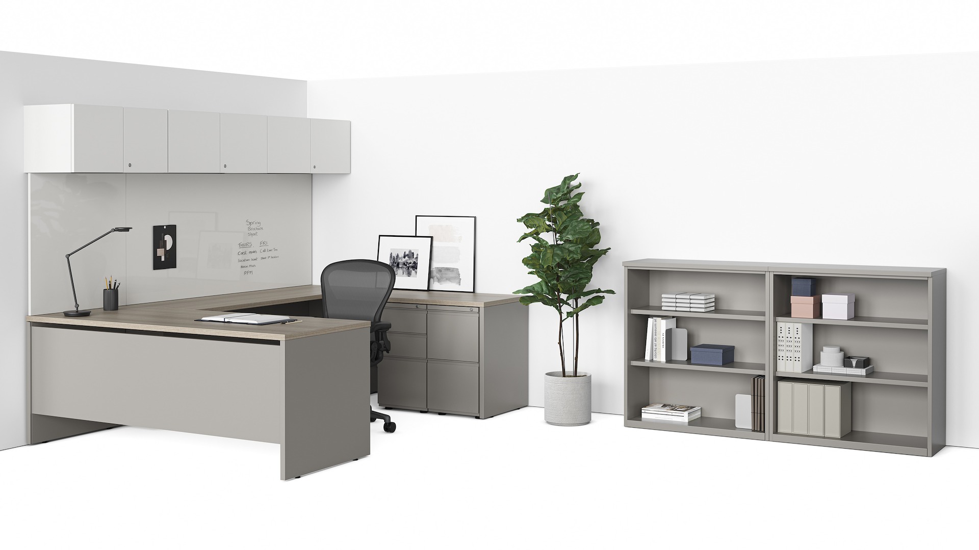 A grey Canvas Metal Desk with white upper storage, a black Aeron Chair, and storage cabinet. 