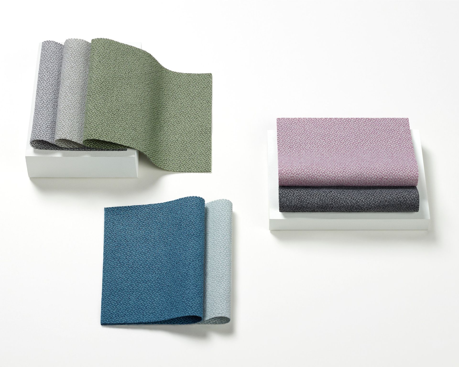 A top view of multiple, folded calming neutral fabrics.