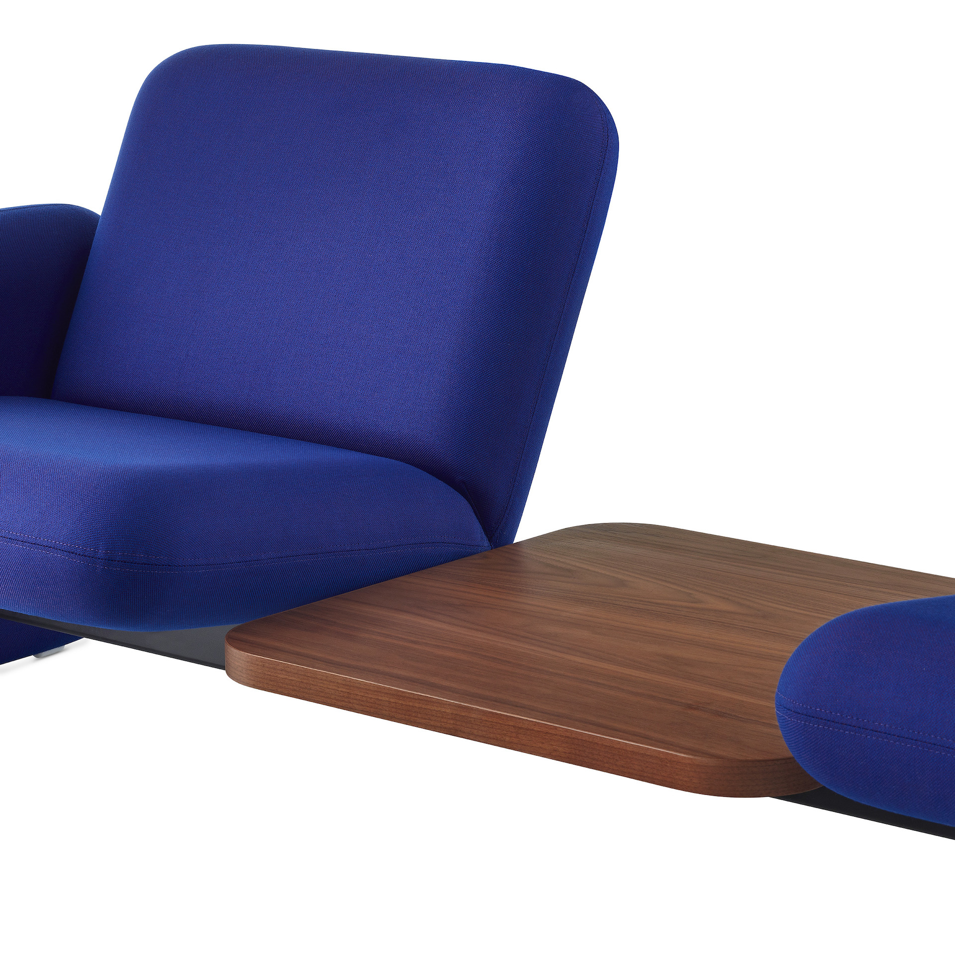 Close of angle view of a brown table between 2 middle seats of a Wilkes Modular Sofa Group Sofa in blue.