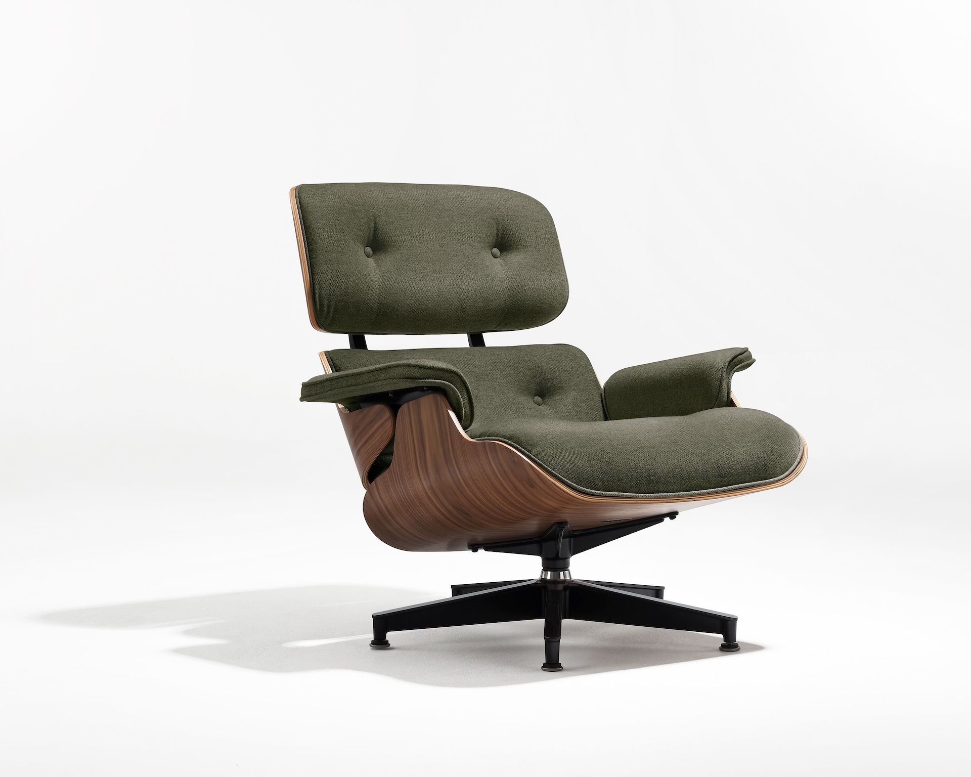 Eames Lounge Chair with green fabric upholstery and walnut frame, viewed from an angle.