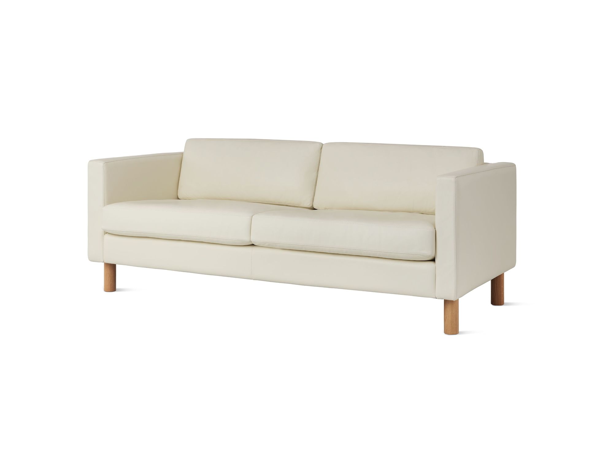 Lispenard Sofa in white leather upholstery and light oak legs, viewed from an angle.