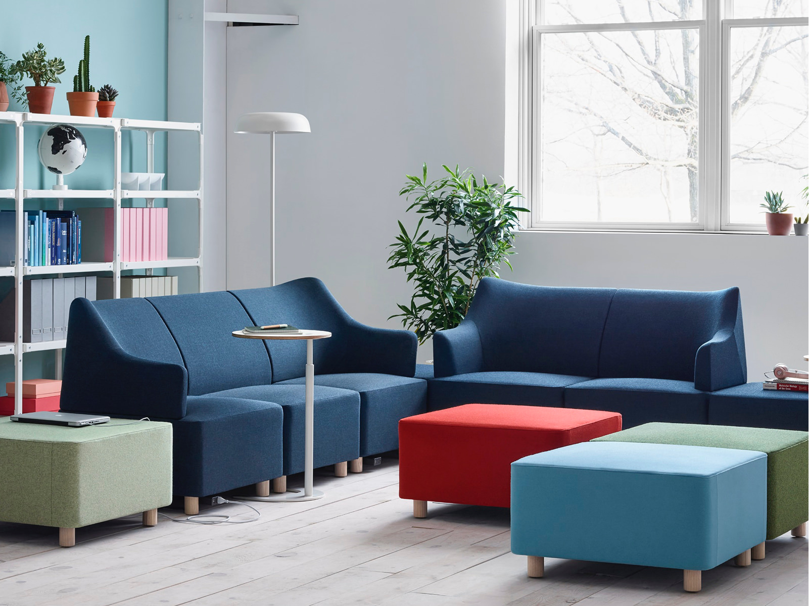A casual sitting area containing modular Plex Lounge Furniture and ottomans in shades of blue, green, and red.