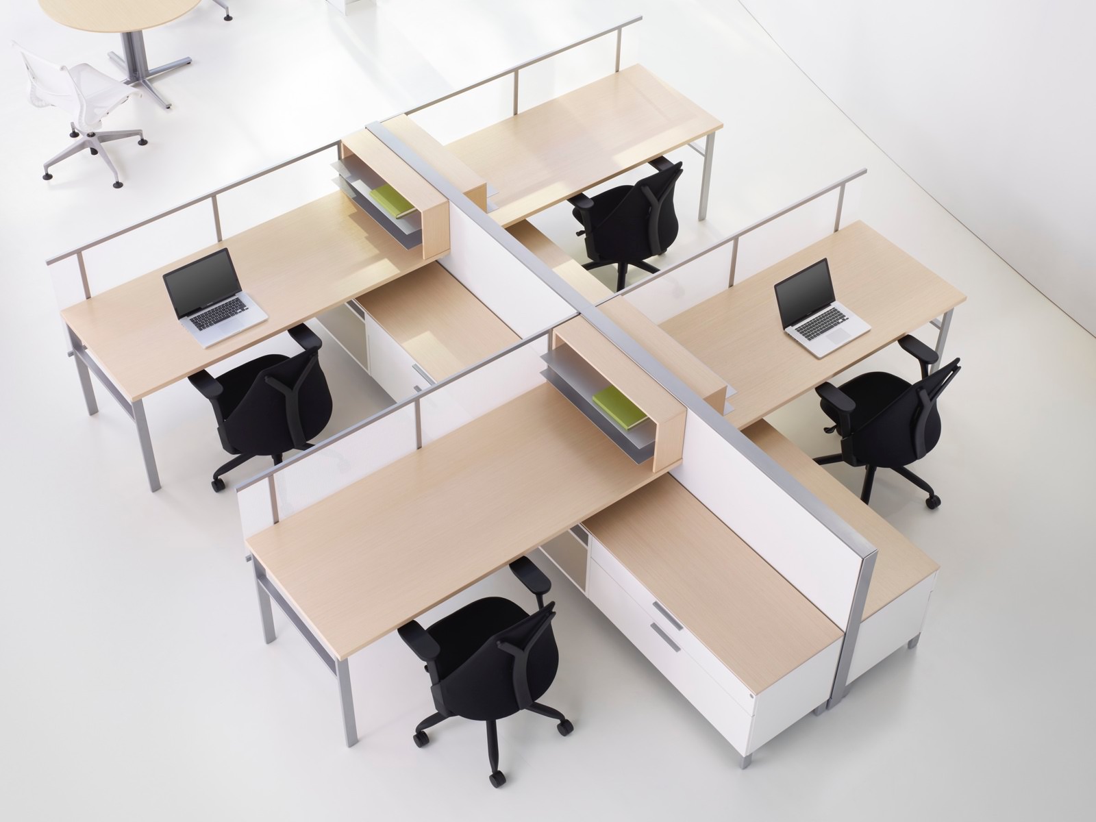 Overhead view of four workpoints with black Sayl office chairs and Canvas Storage surfaces in a light wood finish.