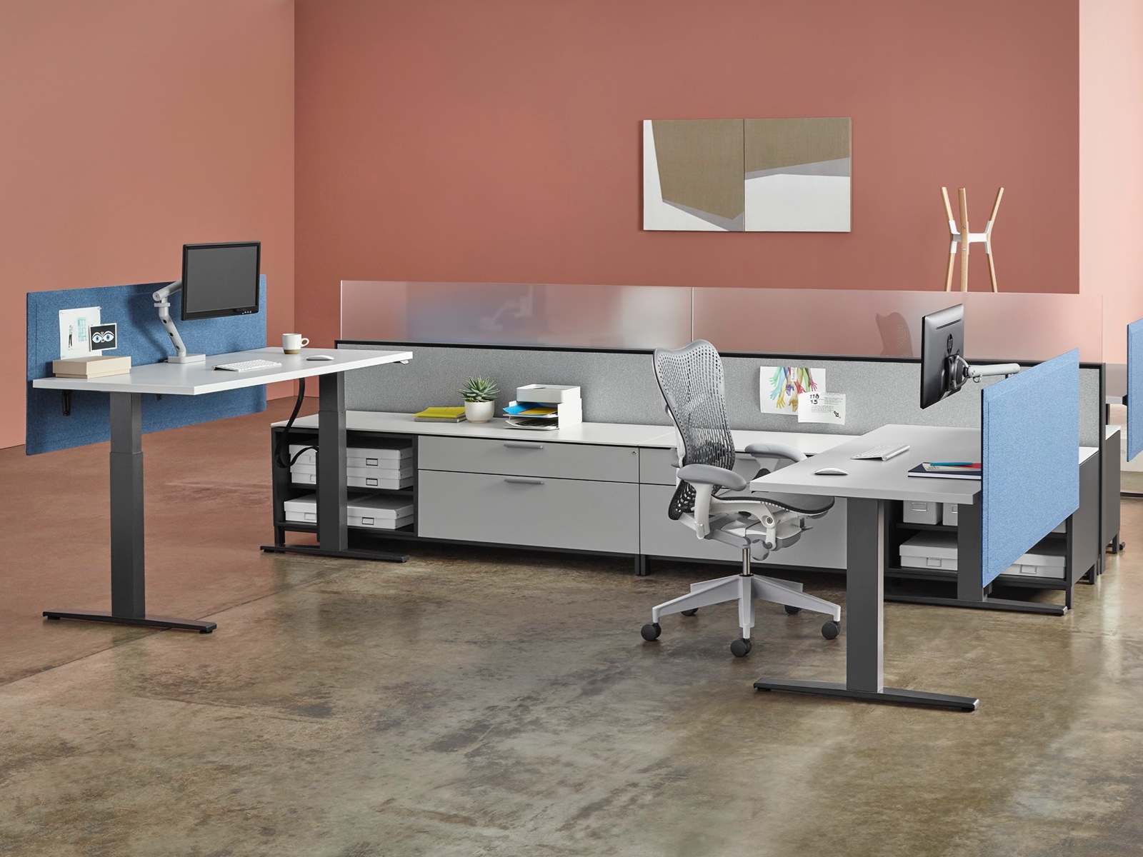 Two workpoints with Motia Sit-to-Stand Tables positioned at different heights, shared Canvas Office Landscape storage, and Plex Lounge Furniture nearby.