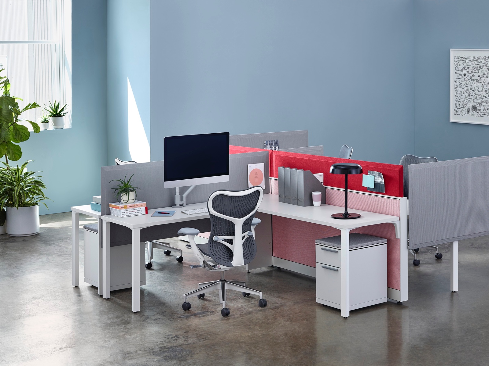 A cluster of four Canvas Wall workstations with white 90-degree surfaces, gray and red Pari Screens, and gray Mirra 2 office chairs.