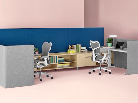 Back-to-back workstations consisting of Canvas Dock storage, Renew Sit-to-Stand Tables, blue and gray freestanding Pari Screens, and gray Mirra 2 Chairs.