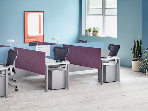 Pari Screens in light blue and patterned mauve create boundaries between a cluster of six workstations featuring Canvas Dock surfaces and Mirra 2 Chairs.